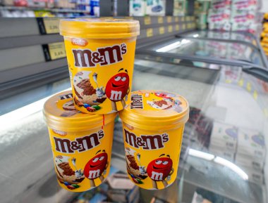 İtalya - 29 Temmuz 2023: MM 'ler İtalyan bir süpermarketin soğutmalı tezgahında plastik kavanozlarda fıstık aromalı çikolata aromalı dondurma markası