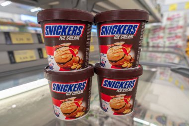 İtalya - 29 Temmuz 2023: Bir İtalyan süpermarketinin soğutmalı tezgahında plastik kavanozlarda Snickers dondurması