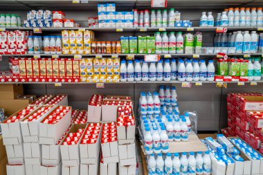 İtalya - 08 Ağustos 2023: Süt plastik şişelere ve kutulara doldurulmuş çeşitli yiyecek kutuları ve markalar İtalyan indirimli süpermarketlerinde satılmak üzere raflara dizilmiş. 