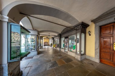 Cuneo, Piedmont, İtalya - 16 Ağustos 2023: Roma şehir merkezinde retro-stil mağazaları olan tarihi binaların altındaki tipik atari salonlarının manzarası