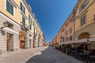 Cuneo, Piedmont, İtalya - 16 Ağustos 2023: Antik binalar dekore edilmiş ve tarihi merkezde atari salonu olan Via Roma ana kaldırım taşı caddesi üzerindeki şehir manzarası