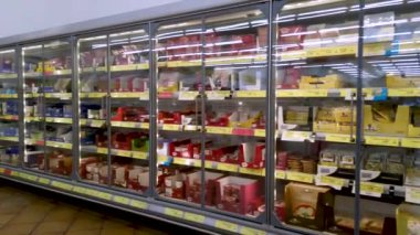 İtalya - 06 Ağustos 2023: Süt ürünleri ile soğutmalı vitrinler ve İtalyan indirimli market süpermarketinde salam. Çekim