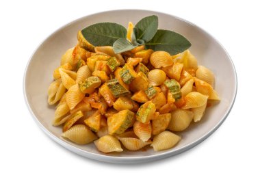 Conchiglie rigate makarnası. Kabuklu makarna şeklinde makarna ve domates sosu beyaz tabaktaki adaçayı yaprakları kırpma yolu dahil olmak üzere beyaz tabakta.