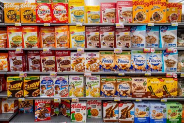 Italy - August 14, 2023: Flakes of various types and brands in boxes displayed on shelves for sale in Italian supermarket