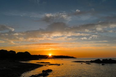 Fransa 'nın Korsika kıyısındaki Akdeniz üzerinde renkli bir günbatımı. Muhteşem gökyüzü manzaralı deniz manzarası
