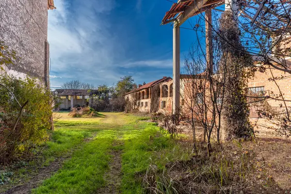 stock image Old abandoned farmhouse with typical rural architecture of the Po Valley in the province of Turin, Italy. Rural dwelling with ruins of stable and barn under brick arches 