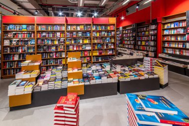 İtalya - 11 Aralık 2023: Satılık kitap yığınları ve rafları olan İtalyan kitapçısı 