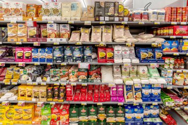 İtalya - 15 Aralık 2023: İtalyan süpermarketlerinde satışa sunulan çeşitli markaların çeşitli paketlerinde pirinç