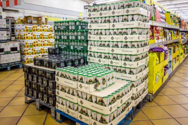 İtalya - 15 Aralık 2023: İtalyan süpermarketlerinde satılmak üzere paletlerin üzerine yığılmış çeşitli markalardan çeşitli kutularda çeşitli tipte sarı bira kutuları