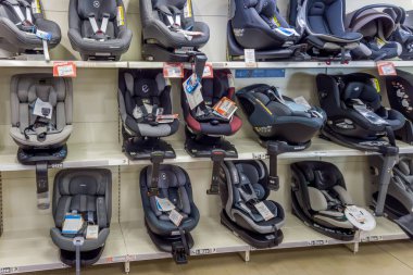 İtalya - 19 Aralık 2023: Bebek mağazasında satılık raflarda çeşitli ve farklı türde bebekler için güvenli oto koltuğu