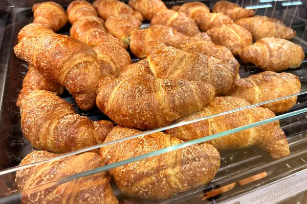 Croissant in self-service dispenser for sale in supermarket bakery department
