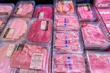 İtalya - 24 Aralık 2023: Dilimlenmiş meze etleri, çeşitli türde vakumlu plastik tepsiler ve İtalyan süpermarketlerinde satılmak üzere soğutulmuş tezgahlarda sergilenmektedir. 