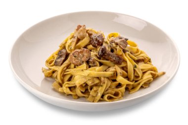 Mantar soslu yumurtalı makarna, beyaz tabaktaki mantarlı tagliatelle, kırpma yolu da dahil olmak üzere beyaza izole edilmiş.