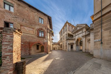 Carignano, İtalya - 18 Kasım 2023: Monte di Pieta üzerinden eski Bona & Delleani yün fabrikasının eski ortaçağ evi ve neo-barok portalı (20. yüzyılın başlarında))