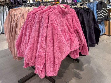 Elbiselerinde satılık çamaşır ipinde sergilenen kadınlar için pembe yün ceketler.