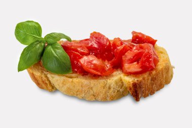 Domates ve fesleğen yaprağı, taze domates parçalı bir dilim ekmek ve kırpma yolu ile beyaza izole edilmiş zeytinyağı.
