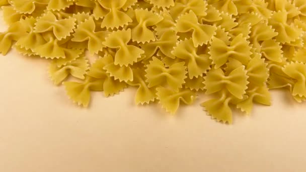 Farfalle Strik Ongekookte Pasta Ongekookt Verspreid Beige Kleur Achtergrond Dolly — Stockvideo