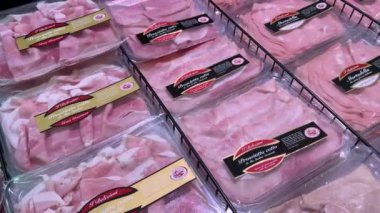 İtalya - Mart 07, 2024: Dilimlenmiş et paketleri İtalyan süpermarketinde soğutucu tezgahında sergileniyor. Doli çekimler keselerde prosciutto, mortadella ve pastırma dilimleri ile yapılıyor. 