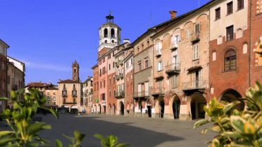 Savigliano, Cuneo, Piedmont, İtalya - 21 Mart 2024: Medeni kulesiyle Piazza Santarosa, tarihi atari salonlu tarihi binaları olan ana coble taş meydan