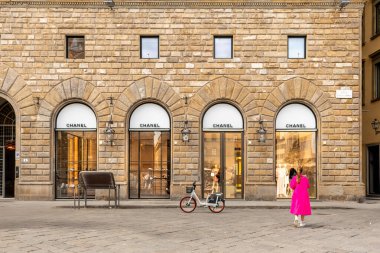 Florence, İtalya - 05 Nisan 2024: Piazza della Signoria 'daki CHANEL FLORENCE butiği, giriş kapısı pencereli ve elektrikli bisikleti kaldırımlı meydanın önünde