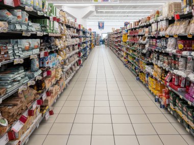 İtalya - 24 Nisan 2024: Bir İtalyan süpermarketinin gıda bölümünde makarna, pirinç ve un içeren raflarla dolu koridor 