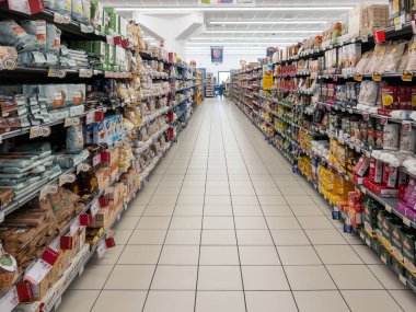 İtalya - 24 Nisan 2024: Bir İtalyan süpermarketinin gıda bölümünde makarna, pirinç ve un içeren raflarla dolu koridor 