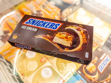 İtalya - 01 Haziran 2024: Fıstıklı ve karamel kaplı Snickers dondurması ve soğutulmuş tezgahta satılığa çıkarılmış çikolatayla kaplı İtalyan Supemarket