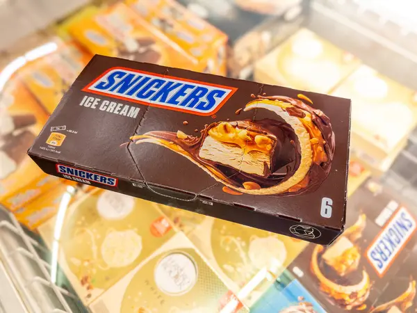 İtalya - 01 Haziran 2024: Fıstıklı ve karamel kaplı Snickers dondurması ve soğutulmuş tezgahta satılığa çıkarılmış çikolatayla kaplı İtalyan Supemarket