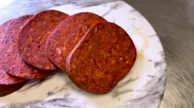 Nduja salamı mermer kesim tahtasında dilimler, Nduja İtalya 'nın Calabria kentinin tipik domuz eti ve biberlerinden yapılan baharatlı bir kremadır. Görüntüyü yakınlaştır