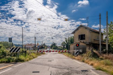 İtalya 'nın Bra kentinde Alba ve Torino arasındaki demiryolu hattında eski terk edilmiş demiryolu kavşağında kırmızı ışıkla kapalı bir geçiş.