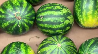 Karpuzlar tepede, karpuzlar meyve tezgahında görüntüleniyor.