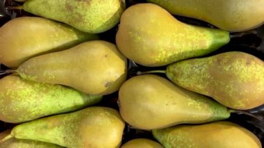 Olgun armutlar kutunun üst görünümünde, meyve standında sergilenen armut konferansında görüntüyü takip ediyor.