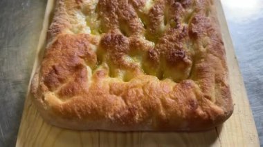Ekstra saf zeytinyağlı Focaccia, Genova 'nın tipik düz ekmeği, en üstteki görüntüde.