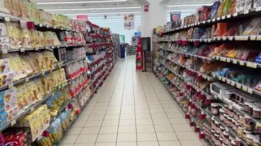 İtalya - 28 Ağustos 2024: Koridor tatlıları, şekerler, abur cuburlar, raflar arasında İtalya süpermarketinde satılık paketlerle sübjektif izleme çekimi