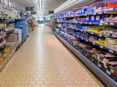 Fossano, İtalya - 10 Eylül 2024: Süt ürünleri ile soğutulmuş raflarla dolu koridor ve İtalyan Lidl indirim mağazasında bakkaliyeli raflar