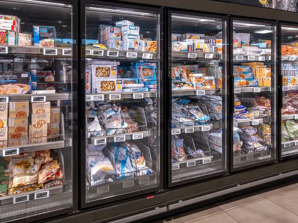 İtalya - 25 Eylül 2024: Donmuş balıklar, İtalyan süpermarketlerinde satılmak üzere büyük soğutmalı vitrinlerde paketlenip sergilendi