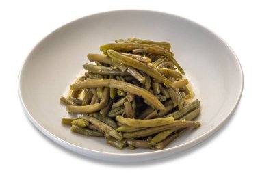 Beyaz tabakta zeytinyağıyla tatlandırılmış haşlanmış yeşil fasulye. Kırpma yolu da dahil olmak üzere beyaza izole edilmiş.