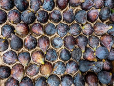 Kara görev incirleri karton kutuda en üstte, siyah incirler ise tam çerçeve arkaplanda.