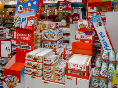 İtalya - 12 Ekim 2024: İtalyan süpermarket koridorlarında istiflenmiş ve sergilenmiş paketler içindeki Kinder Ferrero atıştırmalık ürünleri