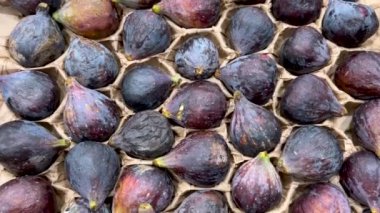 Siyah görev incirleri karton kutuya yerleştirilmiş. Siyah incir üzerindeki çekim tam çerçeve arkaplan olarak takip ediliyor