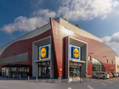 Savigliano, İtalya - 25 Ekim 2024: Lidl indirimli mağaza dış yüzeyi, girişlerde büyük lidl imza logoları, geometrik şekilli dış mimari. 