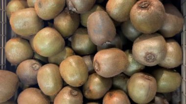 Kiwifruit manavın tezgahındaki sandıklara yerleştirildi, Kivi 'nin görüntüsünü takip ettim.