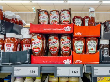 İtalya - 18 Aralık 2024: Lidl süpermarketinde raflardaki sıkıştırılabilir plastik kutulardaki çeşitli markaların ketçapı. Heinz, Calve ve Kania domates 