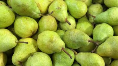 Meyve tezgahında sergilenen armutlar, armutların üzerindeki çekimleri üst görüş alanlarında takip ediyorlar.