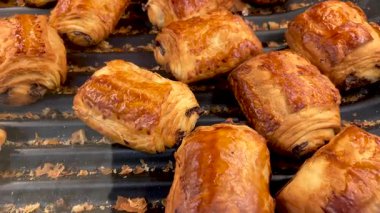 Acı au chocolat: fırının rafında Fransız çikolatalı ekmeği. Taze pişmiş, çikolatalı kruvasanın izini sürüyorum.