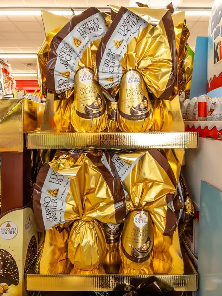 İtalya - 30 Mart 2025: Ferrero Rocher Paskalya Fındığı Koyu Çikolatalı Yumurtalar ve rockçı çikolataları İtalyan süpermarketlerinde satılmak üzere altın karton sergilenmektedir.