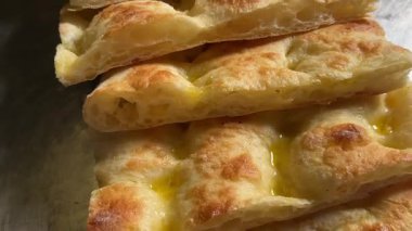 Focaccia Genovese yassı ekmeği, zeytinyağlı ekmek dilimlerinin izini sürüyor.