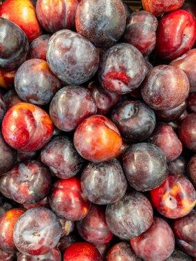 Manavın tezgahında sergilenen olgun erikler.