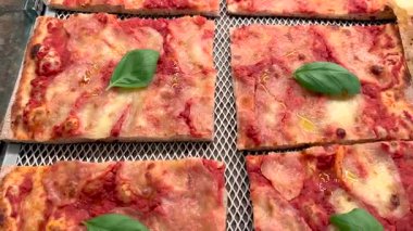 Kare margherita pizzasının taze fesleğen yaprağıyla yukarıdan izlenen görüntüsü