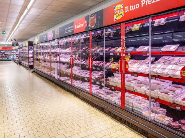 Fossano, İtalya - 10 Haziran 2025: İtalyan LIDL süpermarketinin kasap koridorundaki büyük soğutmalı vitrinlerde çeşitli et paketleri ve kesimleri